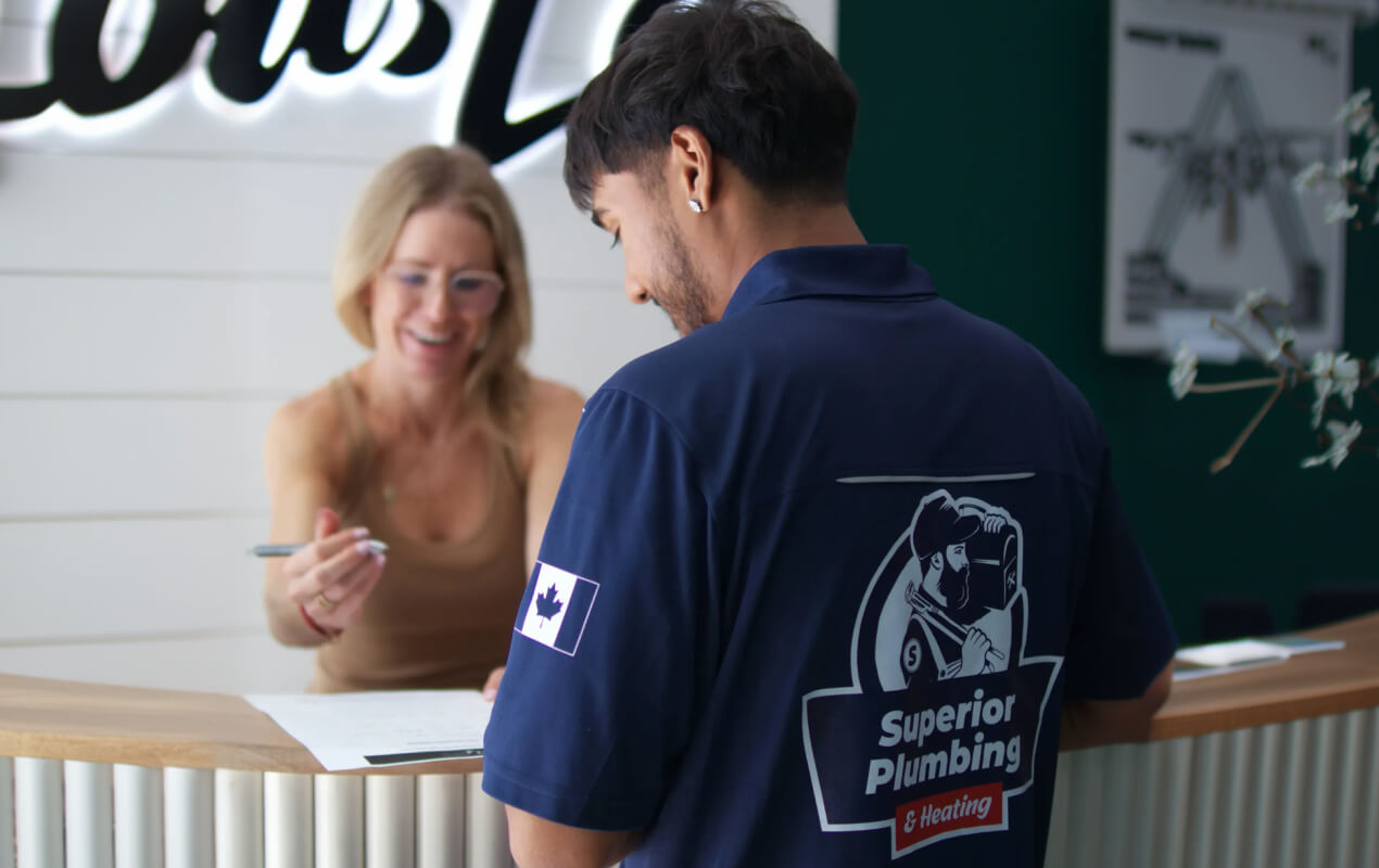 Superior Plumbing & Heating technician providing Commercial plumbing service for a business client at an office desk