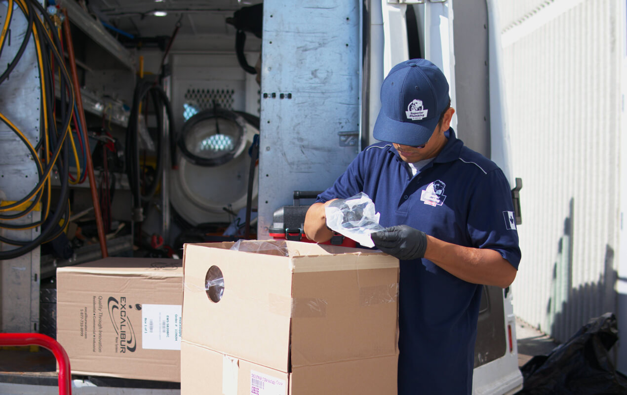 Superior Plumbing & Heating expert preparing professional equipment for a Drain Snaking job from a service van