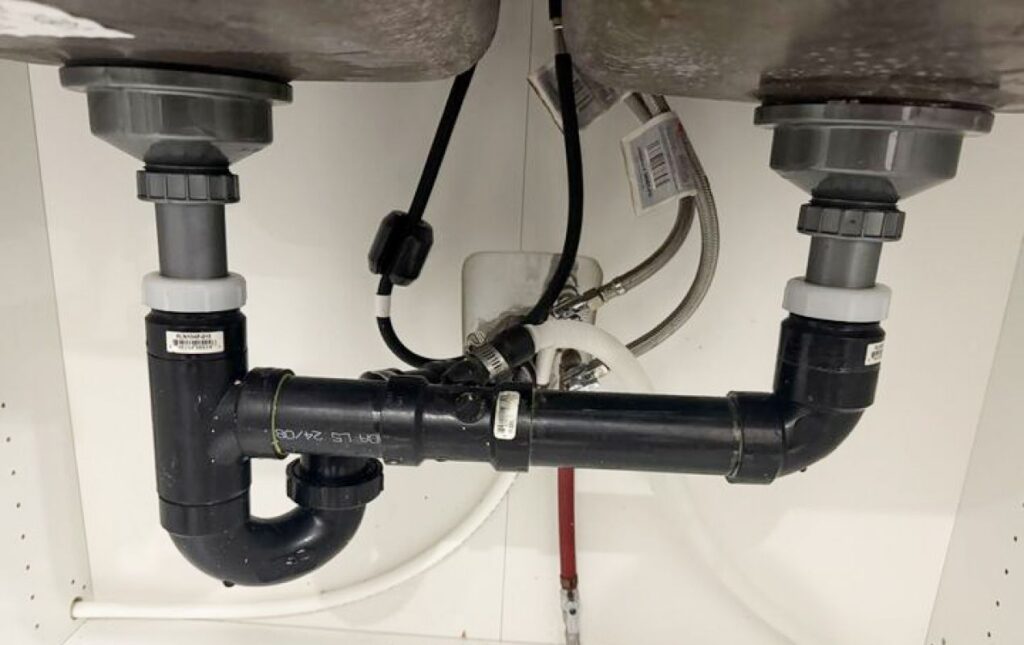 Detailed view of a black drainage manifold after Drain Cleaning local by Superior Plumbing & Heating.