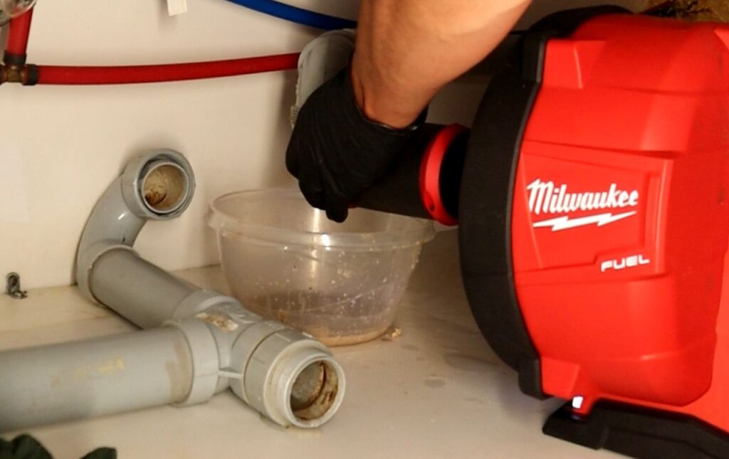 Superior Plumbing & Heating tech using red drain equipment for a Drain Cleaning local call.
