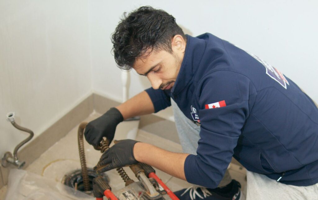 Superior Plumbing & Heating tech using a snake machine for a Drain Cleaning local service.