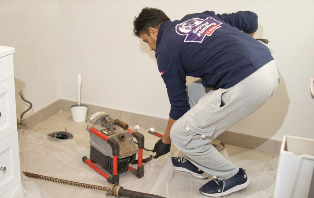 Superior Plumbing & Heating technician operating a machine for Drain Cleaning local.