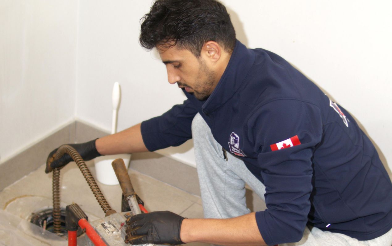 Superior Plumbing & Heating expert using a motorized snake for Drain Cleaning local.