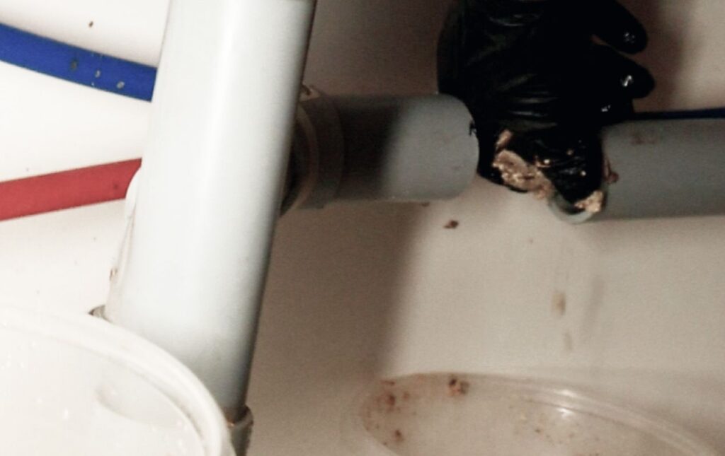 Under-sink pipe inspection during Drain Cleaning local project by Superior Plumbing & Heating.