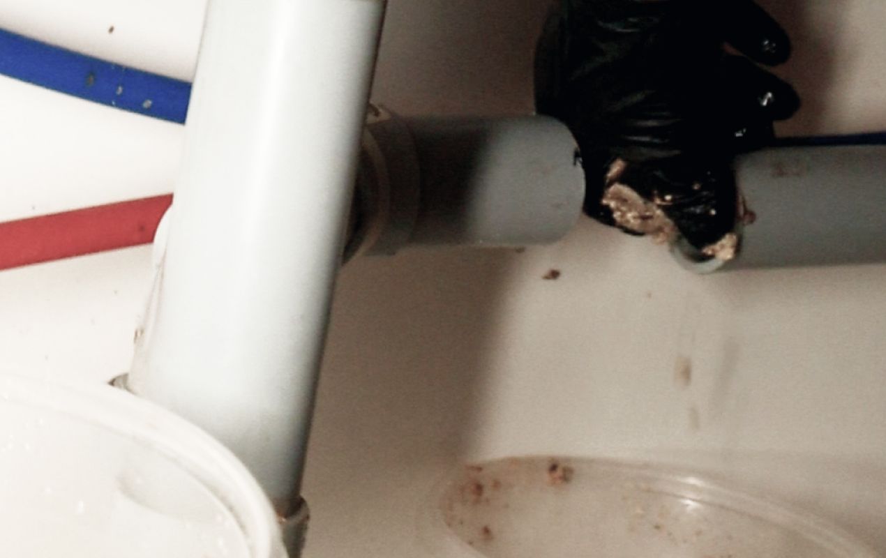 Under-sink pipe inspection during Drain Cleaning local project by Superior Plumbing & Heating.