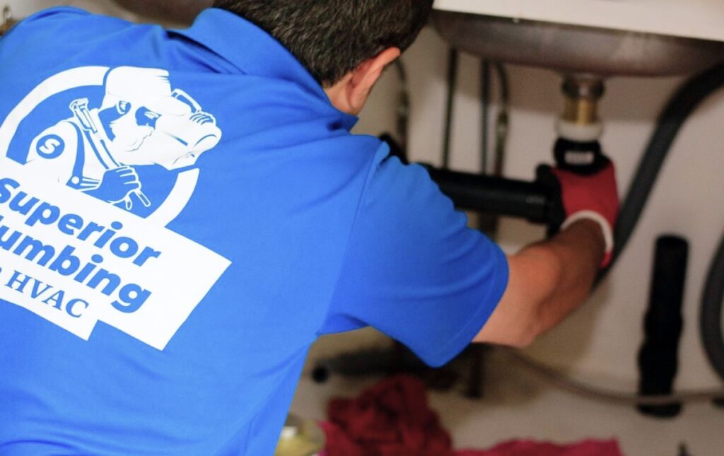 Superior Plumbing & Heating tech repairing a sink drain for Drain Cleaning local service.