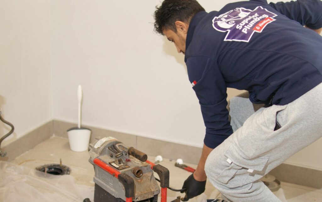 Superior Plumbing & Heating pro preparing a machine for professional Drain Cleaning local.