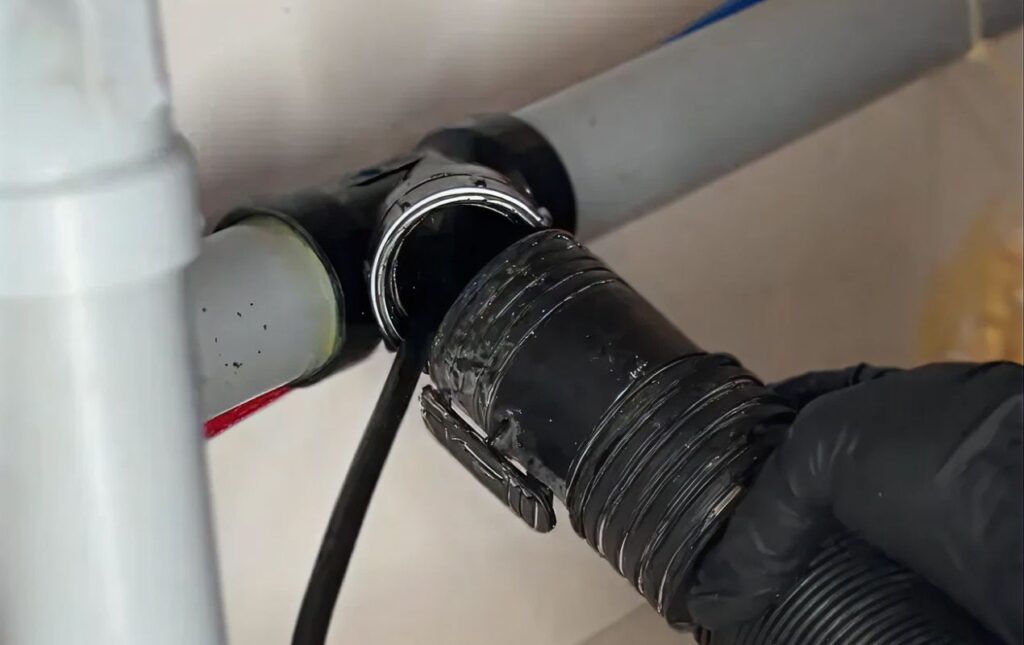 Inserting a cable into a black drain pipe for Drain Cleaning local by Superior Plumbing & Heating.