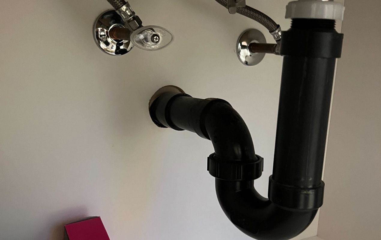 Under sink drain pipes during a Drain Cleaning local by Superior Plumbing & Heating.