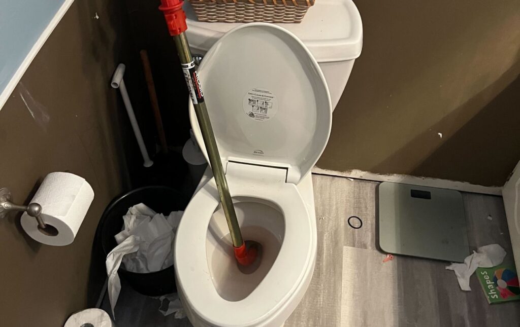 Toilet repair service by Superior Plumbing & Heating clearing a toilet blockage and restoring proper drainage in a residential bathroom