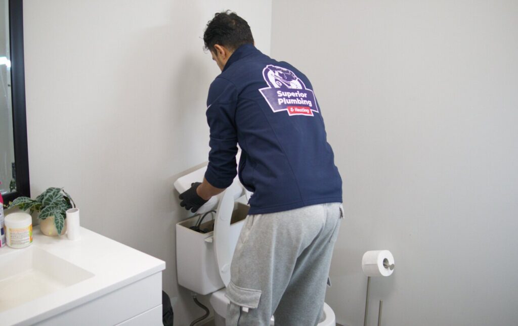 Professional toilet repair service by Superior Plumbing & Heating technician restoring flush performance in a bathroom