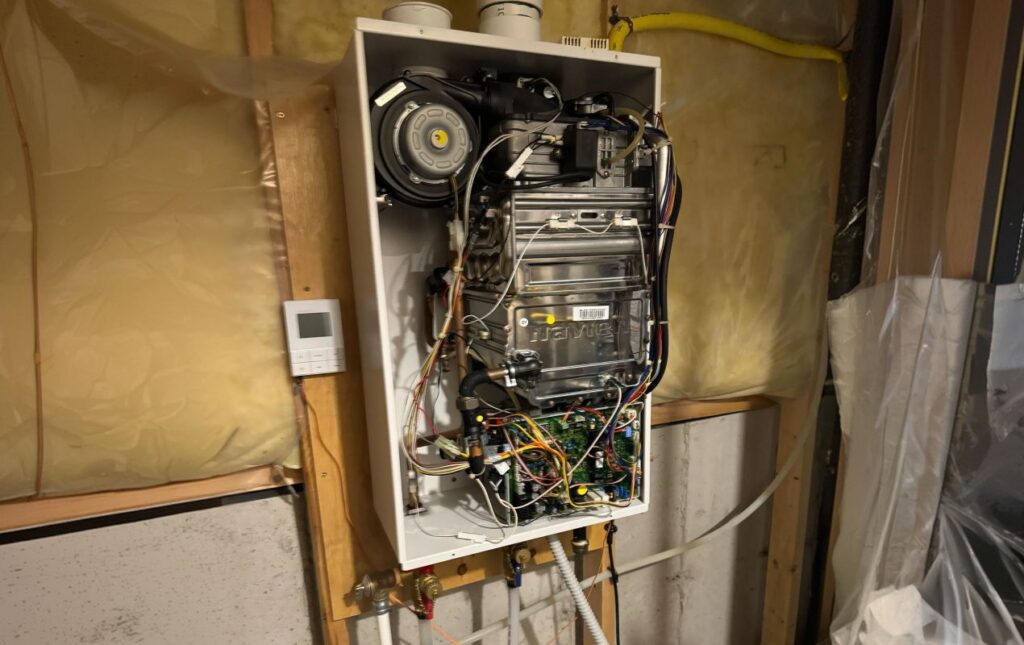 Superior Plumbing & Heating expert Water Heater Repair of an open Navien tankless unit in an unfinished utility room