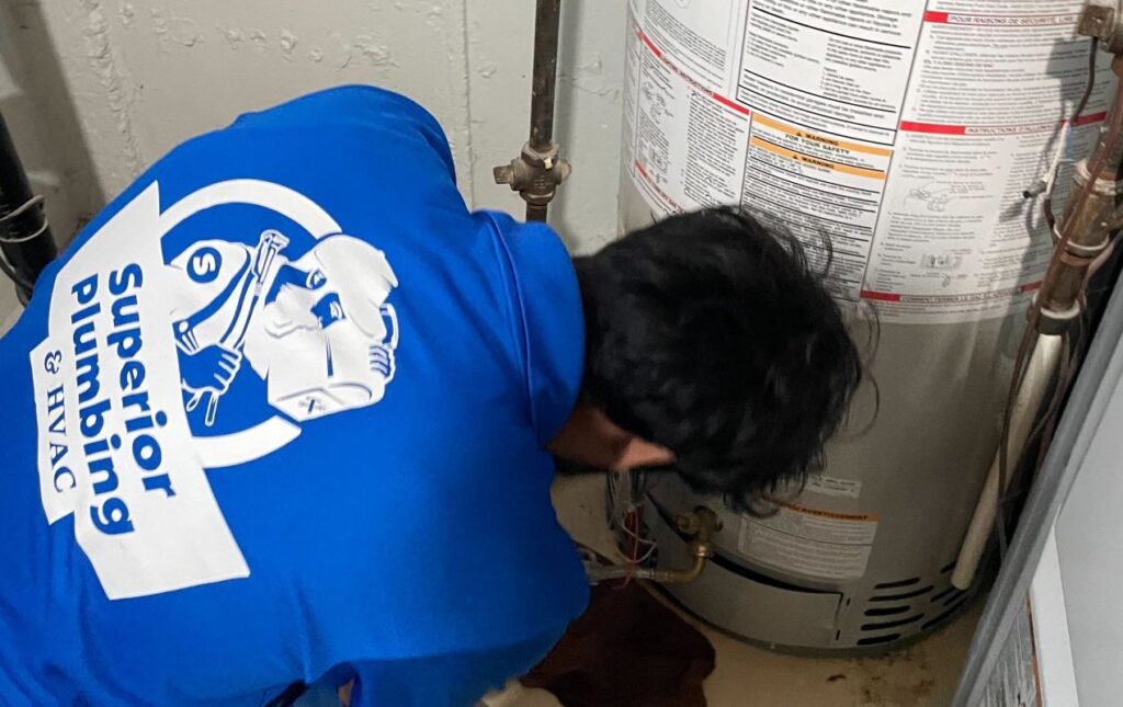Superior Plumbing & Heating expert Water Heater Repair of a gas tank unit by a professional technician in a basement