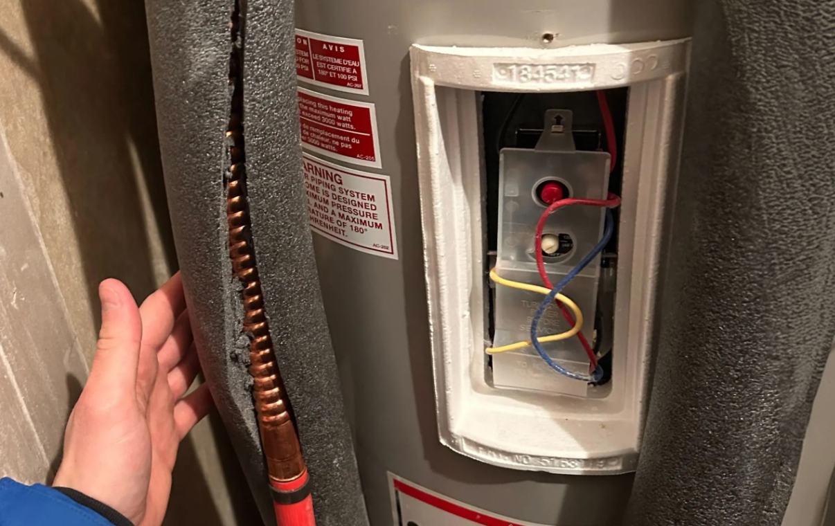 Superior Plumbing & Heating technician performing maintenance on a high-efficiency tankless water heater