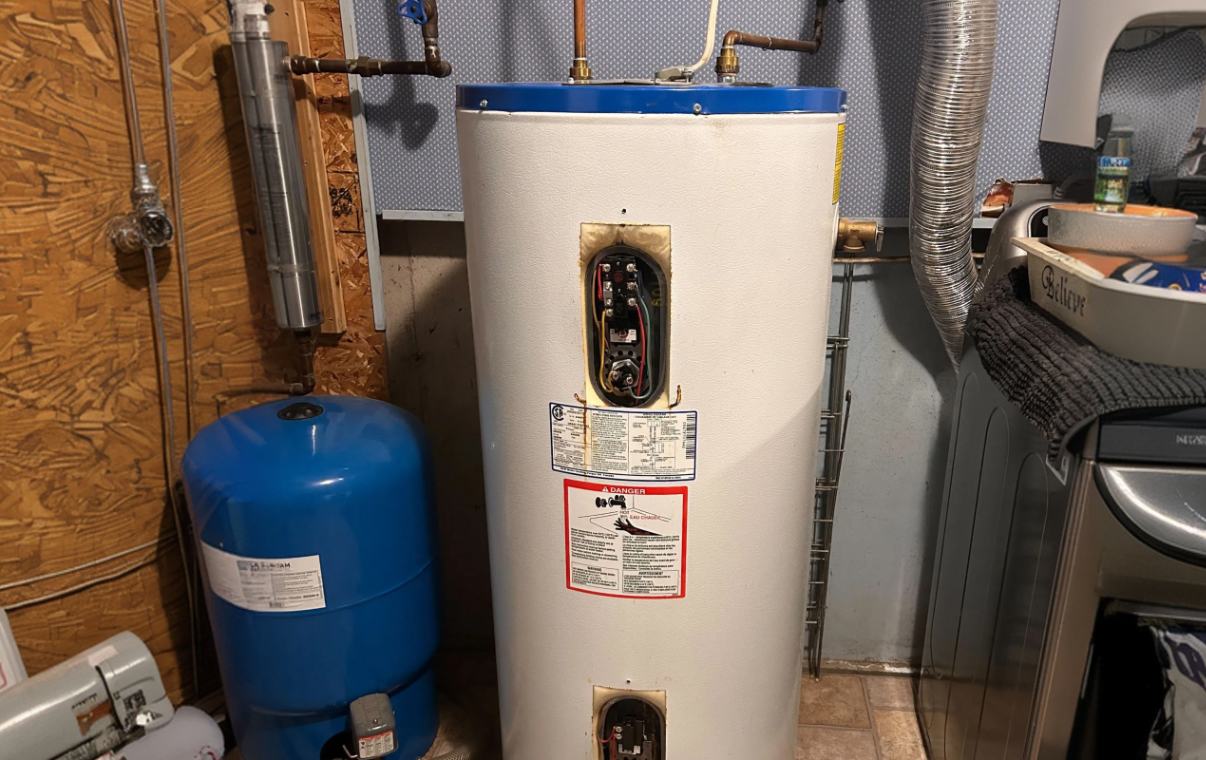 Superior Plumbing & Heating expert Water Heater Repair of a white storage tank with burn damage and blue expansion tank