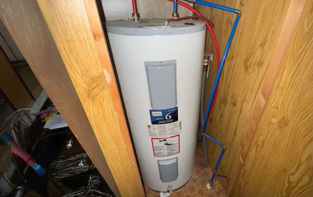 Superior Plumbing & Heating professional Water Heater Installation of a tank unit in a basement with pink walls
