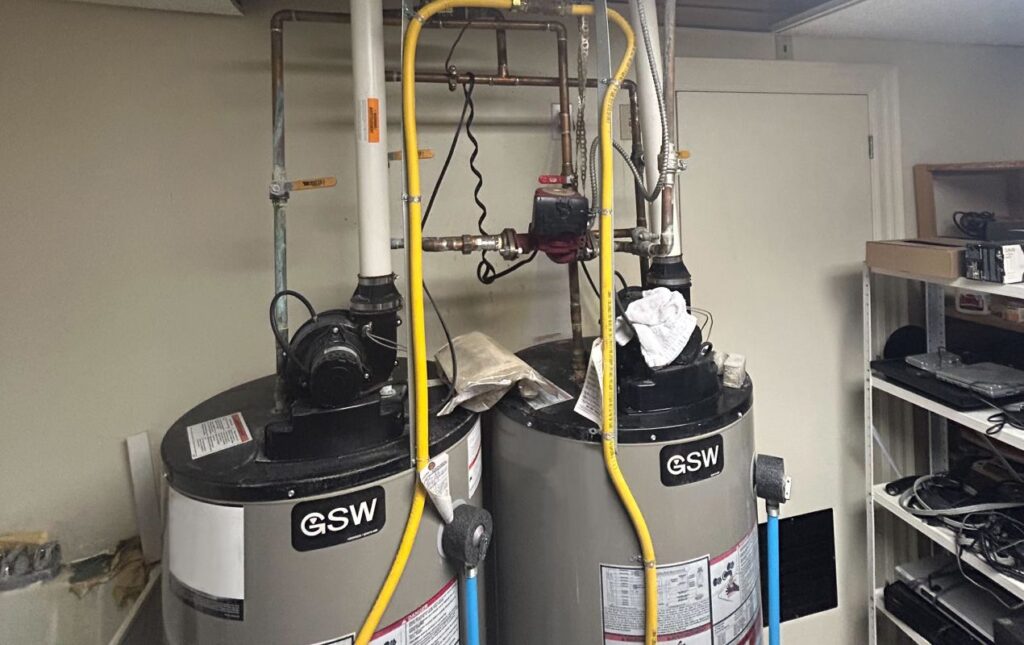 Superior Plumbing & Heating specialist completing professional water heater installation with expansion tank and pressure control system