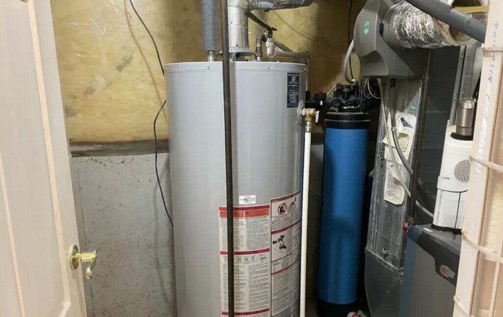 Superior Plumbing & Heating technician installing a gas water heater with integrated water filtration system for improved household water quality