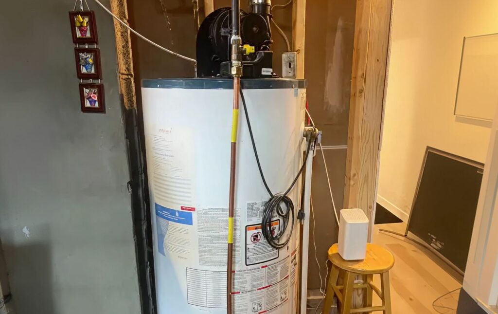 Superior Plumbing & Heating expert installing a residential gas tank water heater with expansion tank and proper venting in a basement utility area