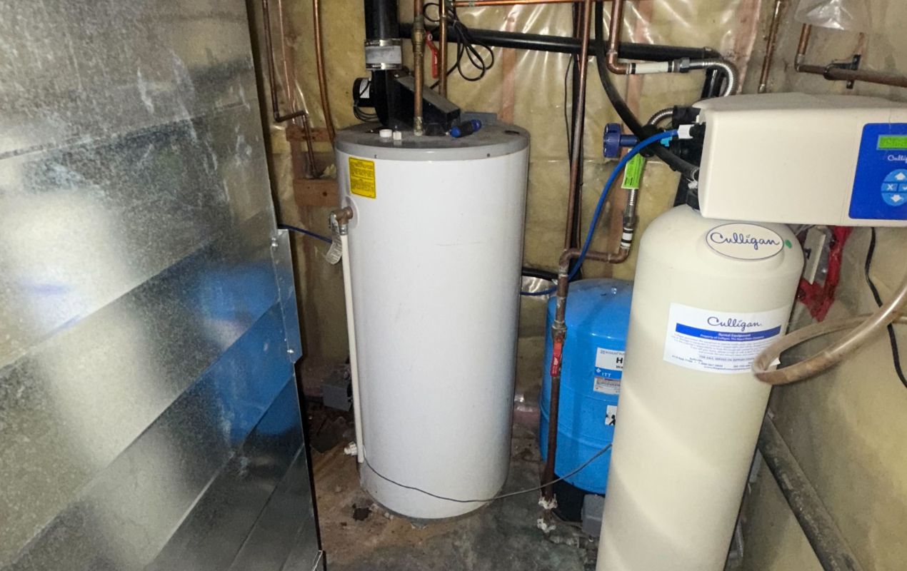 Superior Plumbing & Heating expert Water Softener Repair of a tan resin tank system next to a white water heater