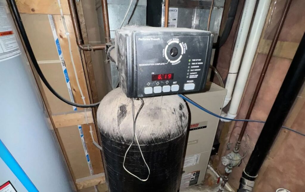 Superior Plumbing & Heating expert Water Softener Repair focusing on a digital control head on a black tank