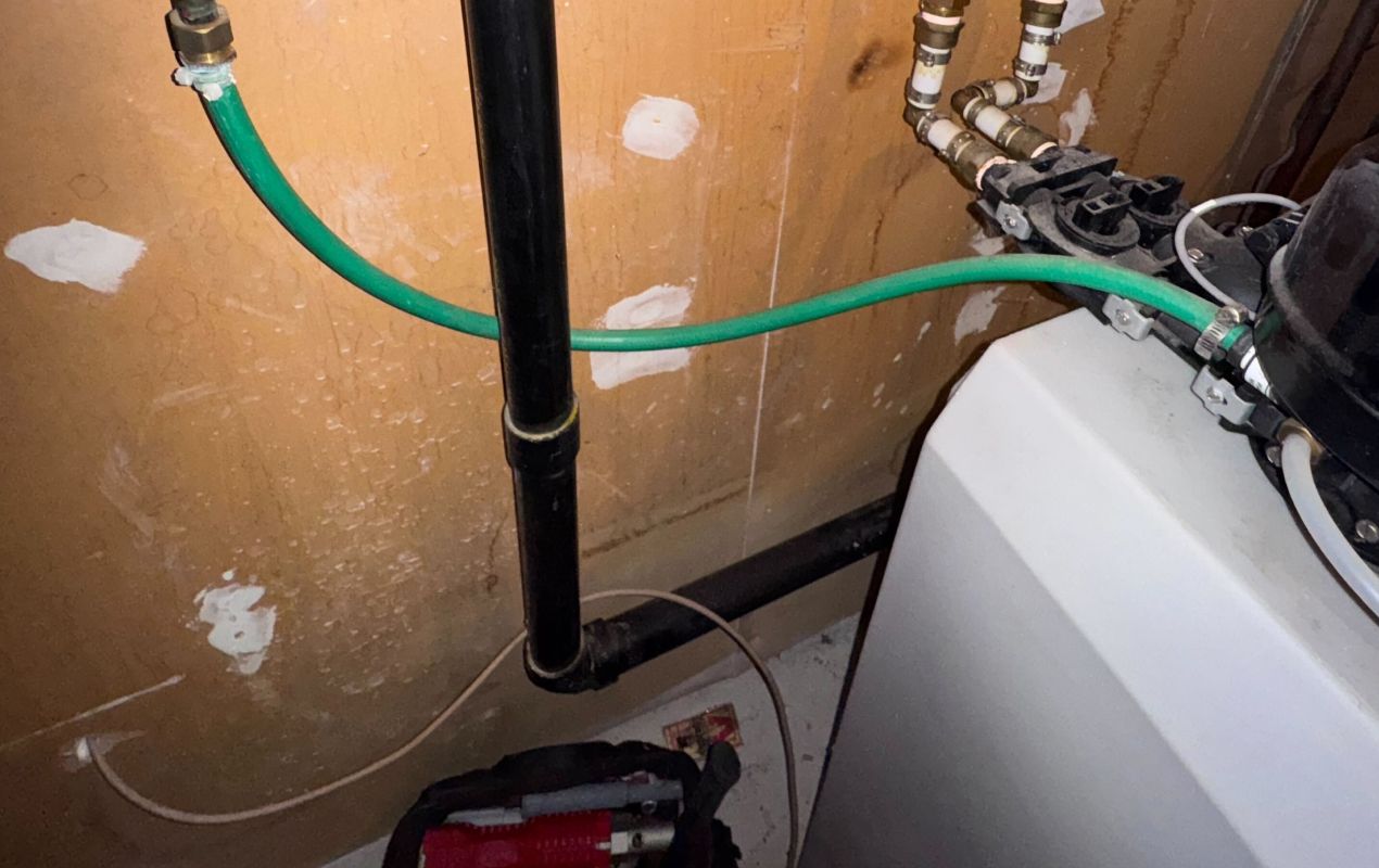 Superior Plumbing & Heating expert Water Softener Repair of drainage pipes and a white cabinet-style residential water softener