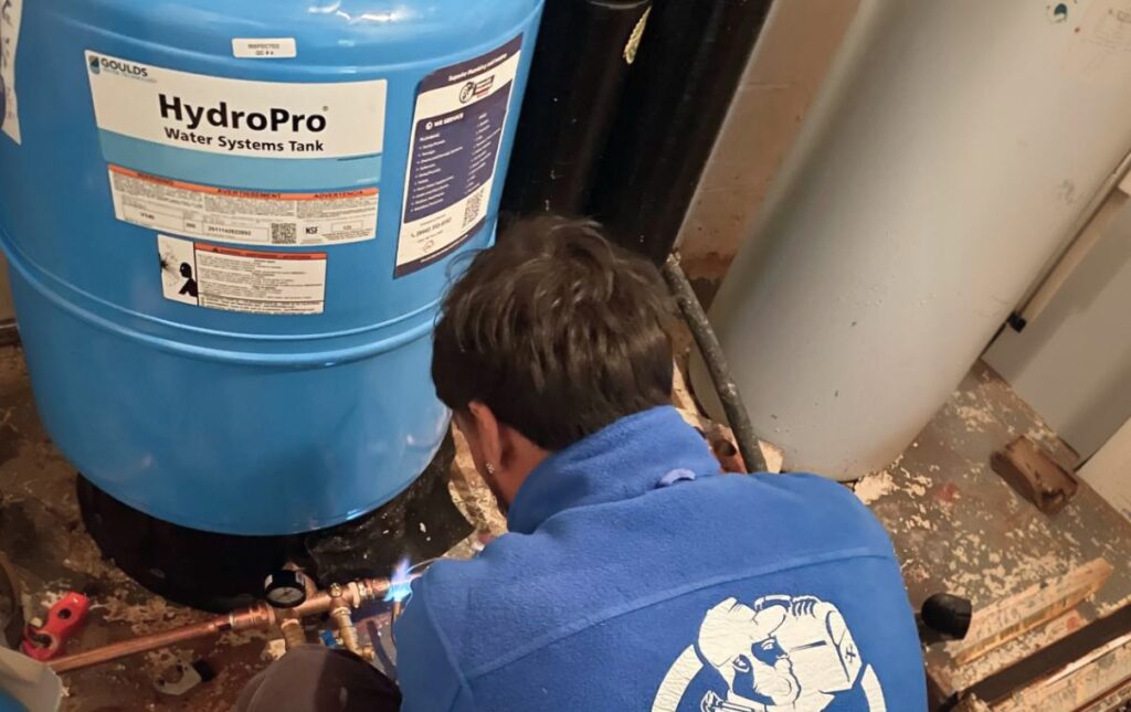 Expert technician from Superior Plumbing & Heating soldering copper lines during a well pump installation local service