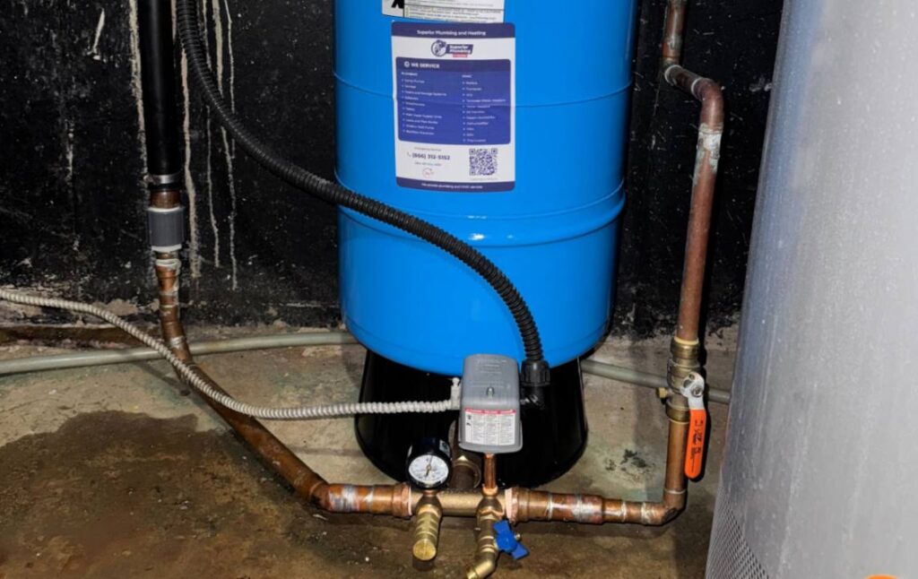 Detailed view of copper pipe connections and a pressure gauge for a well pump installation local by Superior Plumbing & Heating