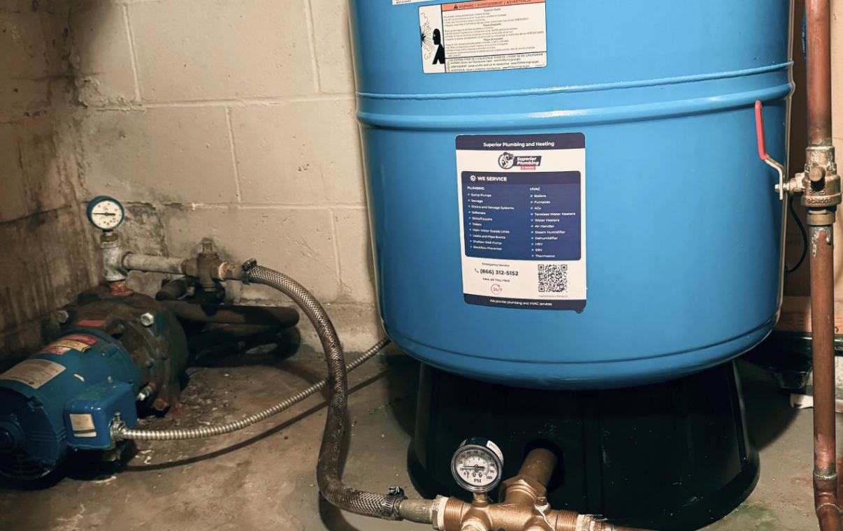 Close-up of a blue pressure tank sitting on a base during a well pump installation local by Superior Plumbing & Heating