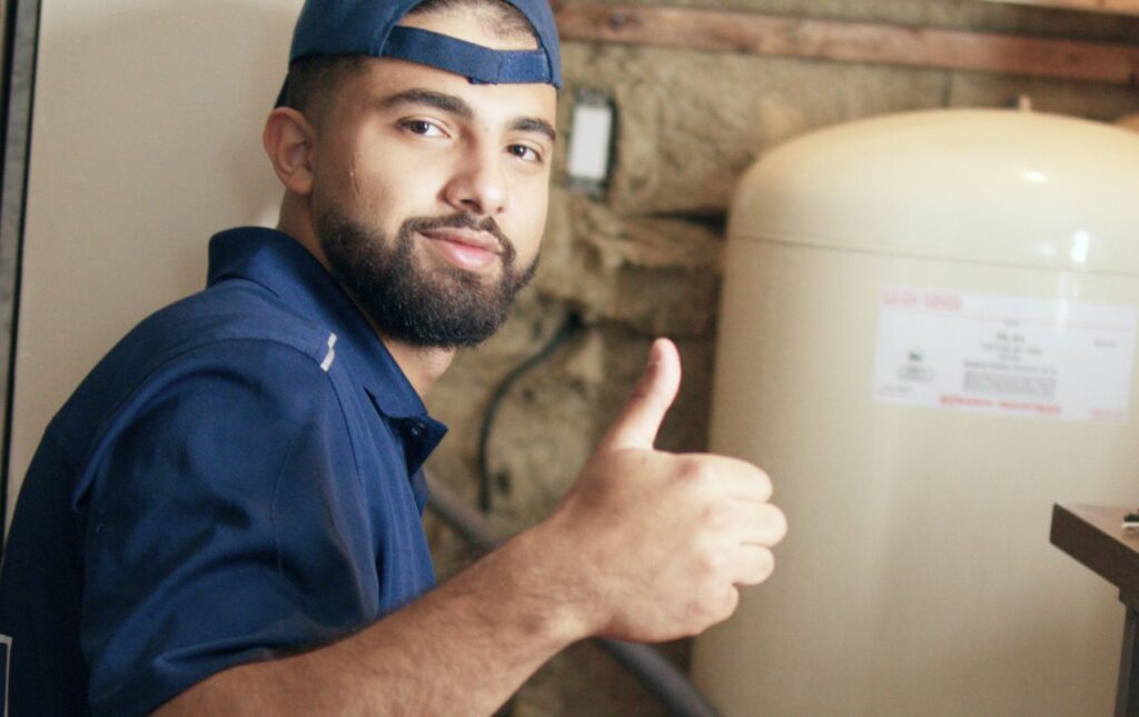 Satisfied Superior Plumbing & Heating professional giving a thumbs up after a well pump installation local