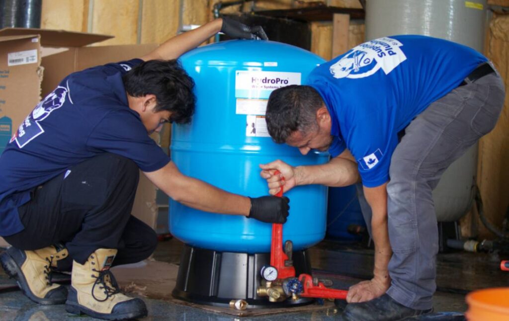 Two skilled technicians from Superior Plumbing & Heating performing a precise well pump installation local