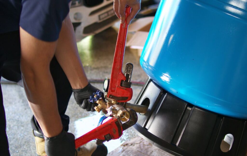 Tightening a fitting for well pump replacement local by Superior Plumbing & Heating.