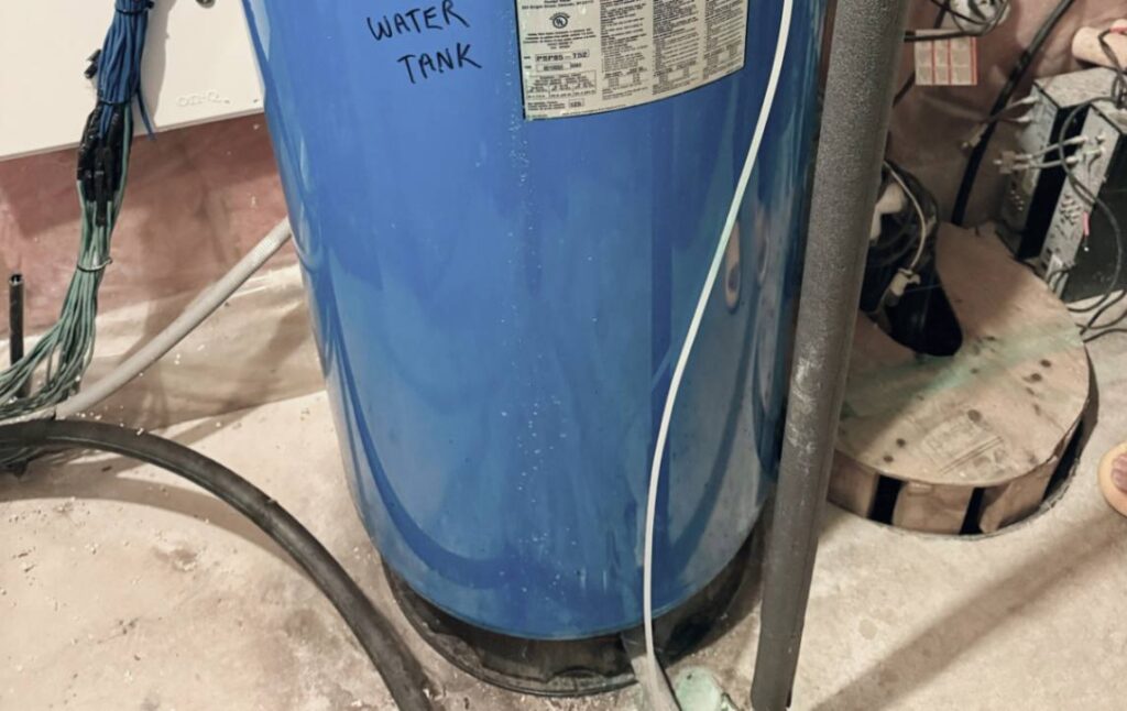 Inspecting water tank base for Well pump repair local by Superior Plumbing & Heating