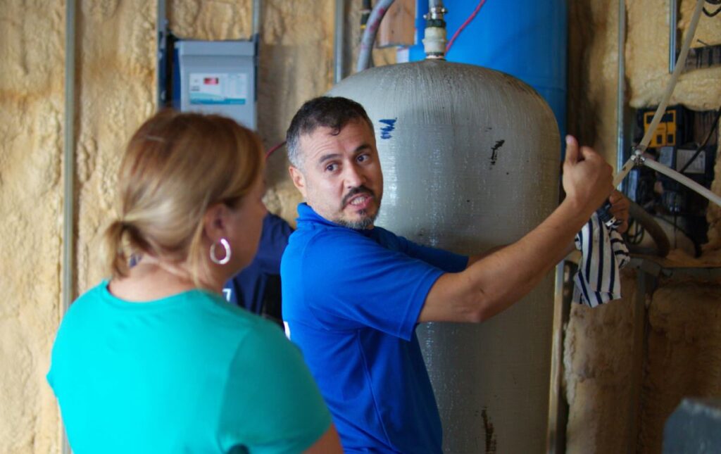 Superior Plumbing & Heating technician consulting with a homeowner about well pump replacement local options