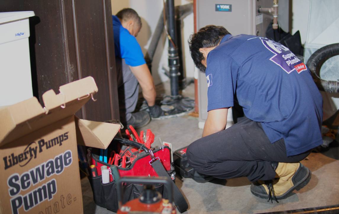 Superior Plumbing & Heating technicians performing a Sump pump replacement local in a residential basement.