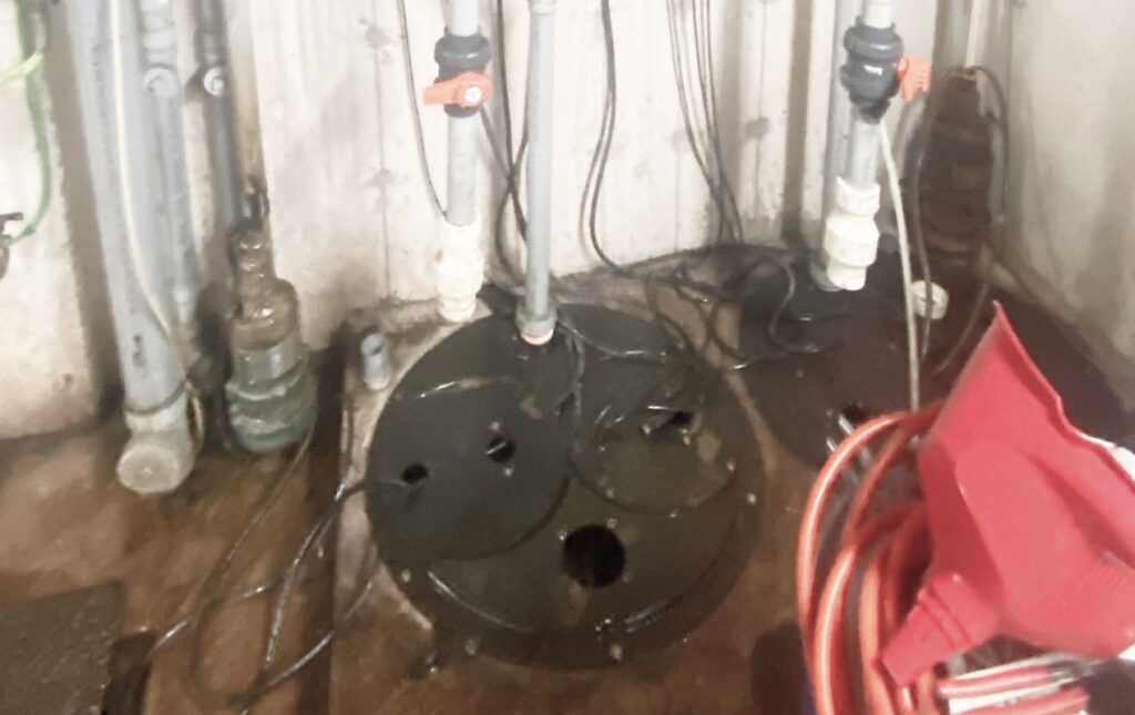 Open basin water level check during a sump pump repair local by Superior Plumbing & Heating.