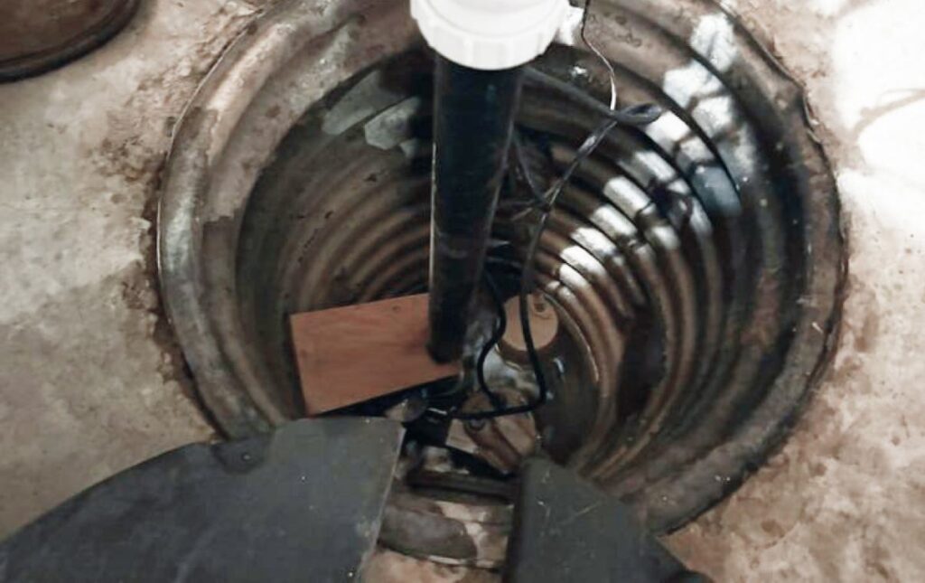 Sump pit piping inspection in a basement for sump pump repair local by Superior Plumbing & Heating.