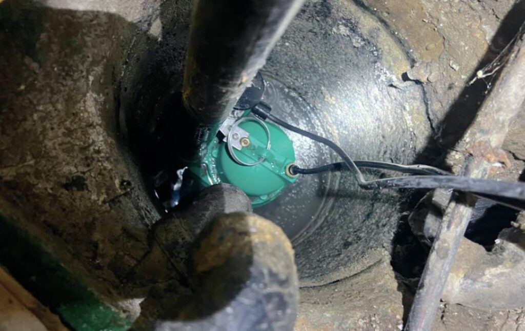 Submersible green pump motor being serviced for a sump pump repair local by Superior Plumbing & Heating