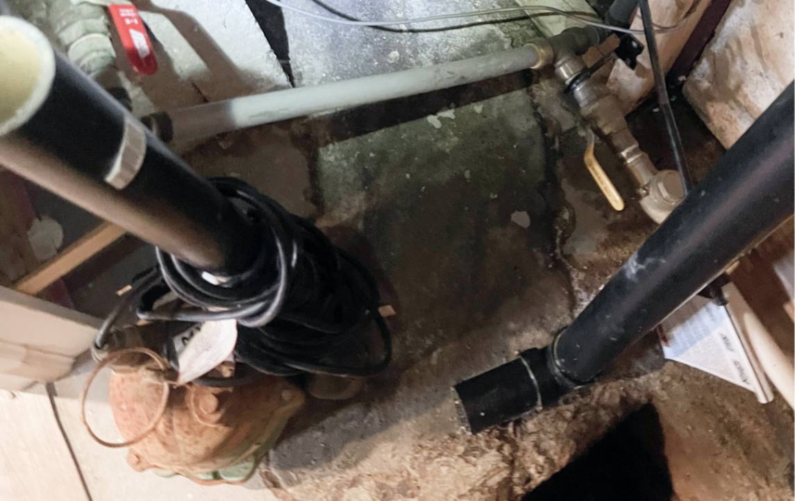 Inspecting rusty basement pipes as part of a sump pump repair local by Superior Plumbing & Heating experts.