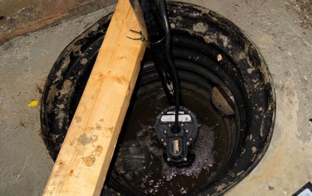 Sump pit inspection with a wooden support during a sump pump repair local by Superior Plumbing & Heating.