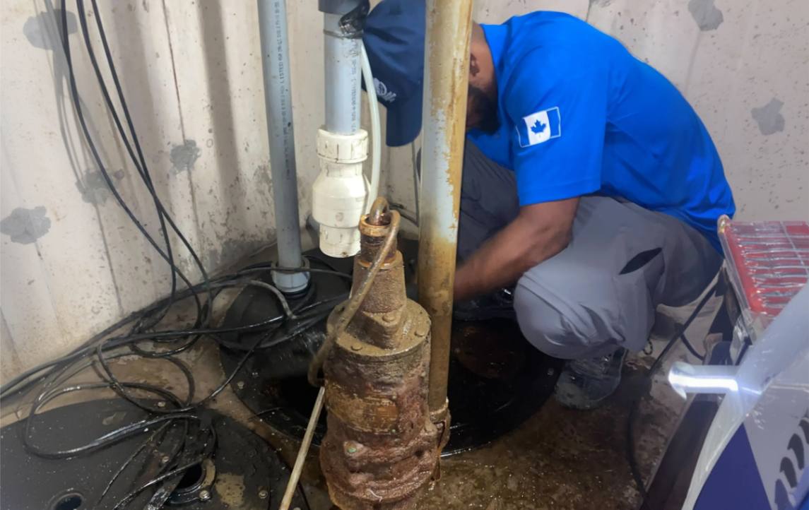 Superior Plumbing & Heating technician inspecting an old unit during a Sump pump replacement service.